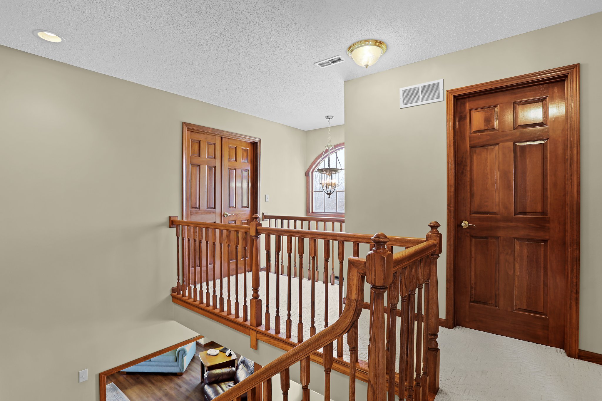 Interior home, second floor landing area, oak wood railing, six panel entry doors and cat walk