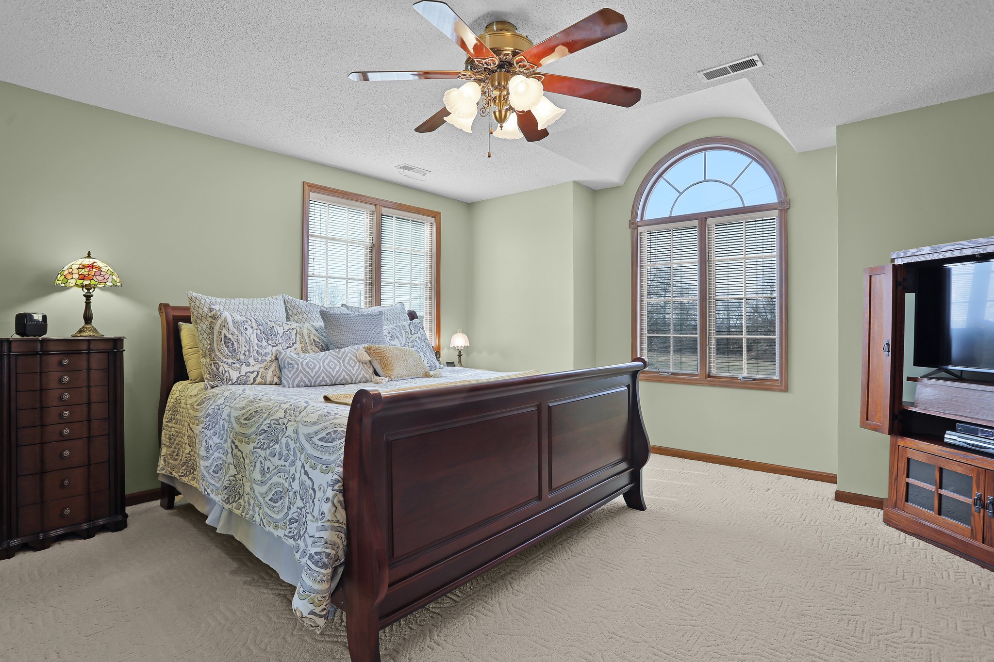 Home Features a Large Primary Suite, Ceiling Fan, Arched Window and Berber Carpet