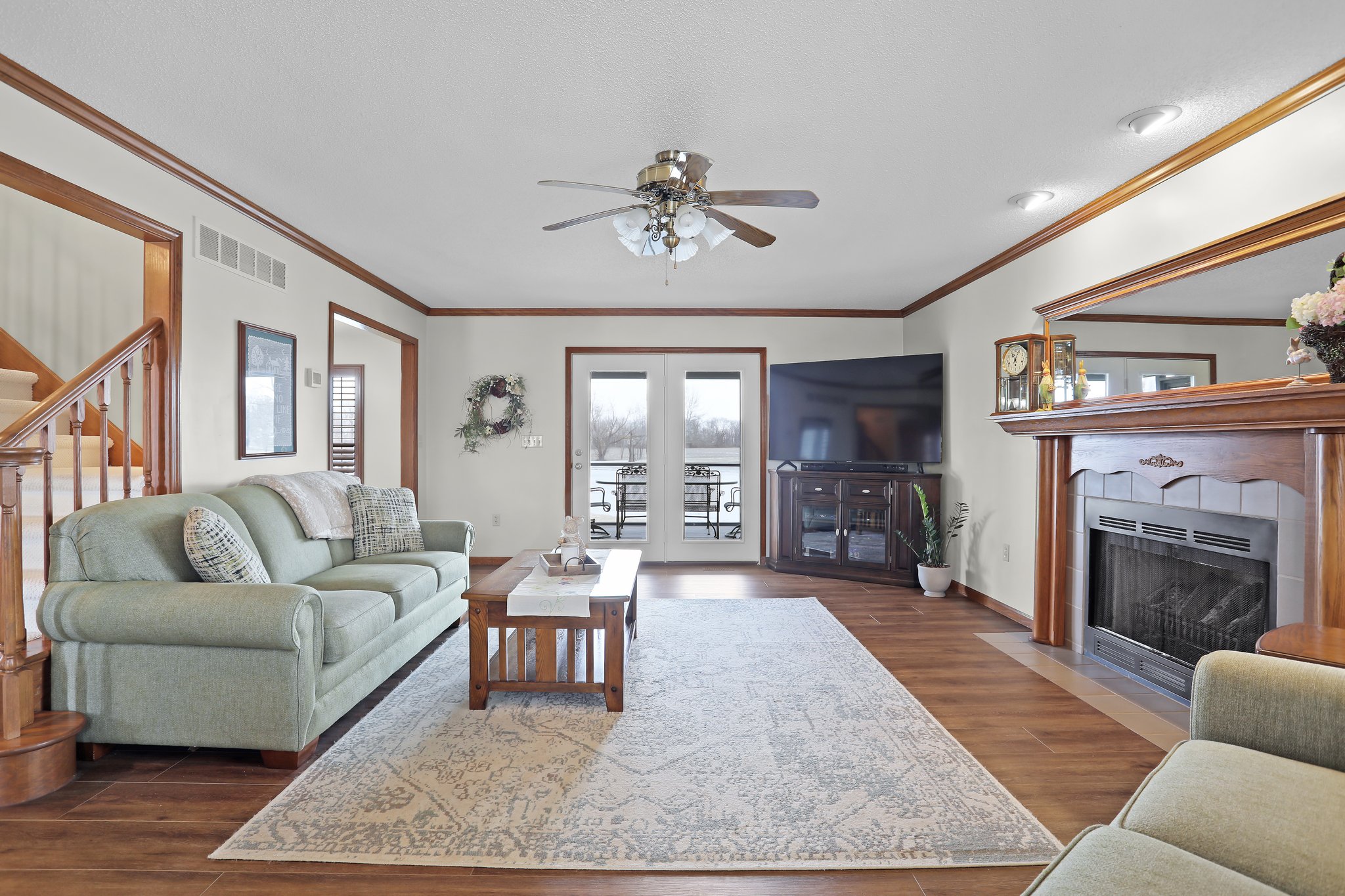 Main Floor Living Area, Luxury Vinyl Plank/Wood Style Flooring, Gas Fireplace, Ceiling Fan and French Doors leading to Screened