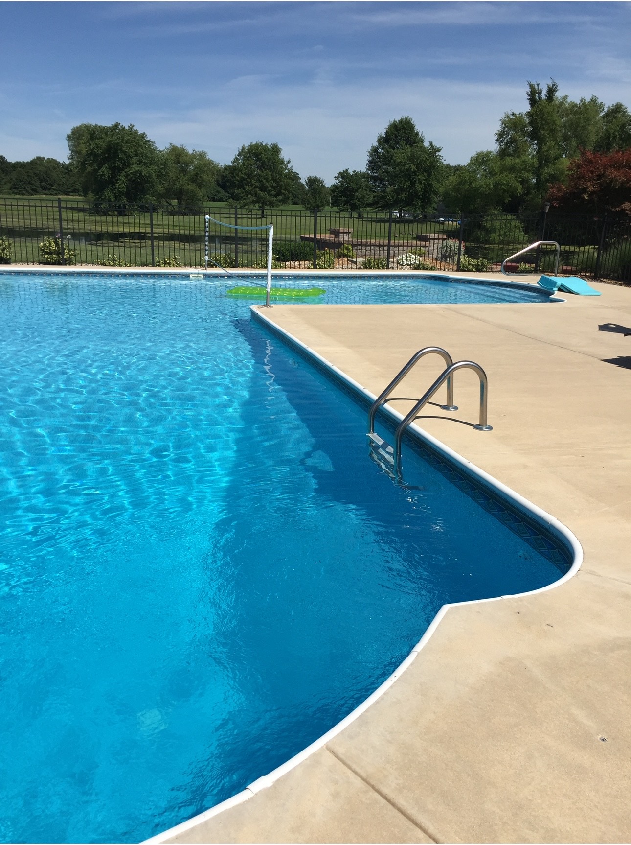 L shaped inground swimming pool, fencing and concrete patio