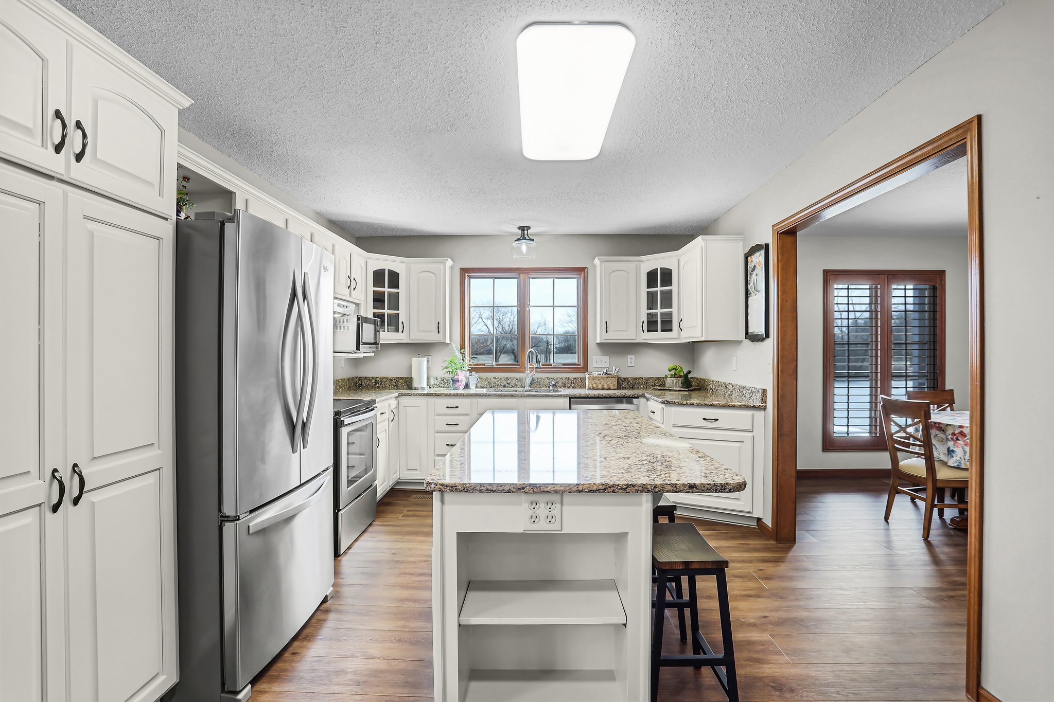Kitchen Center Island, Cambria Quartz Countertops, Off-White Custom Cabinetry with Glass Doors, Luxury Vinyl Plank/Wood Style Flooring, Stainless Steel Appliances