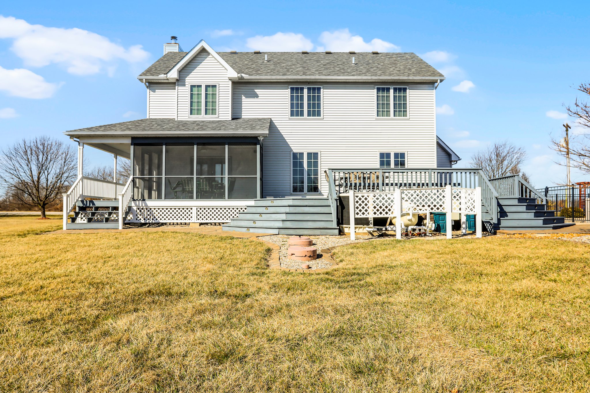 View of backside of home, deck and screened in sunroom