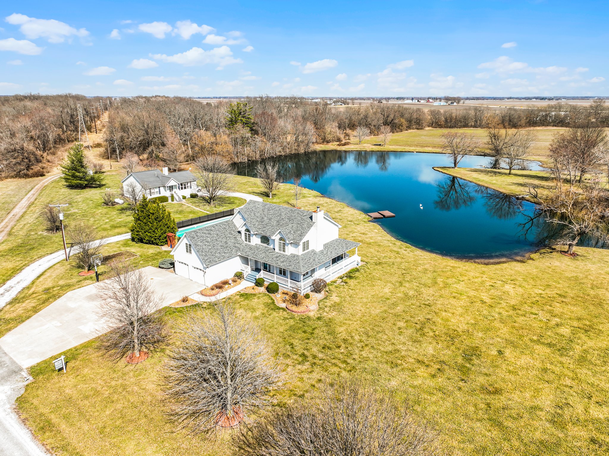 Aerial view of property-acreage, home, inground pool, and large pond