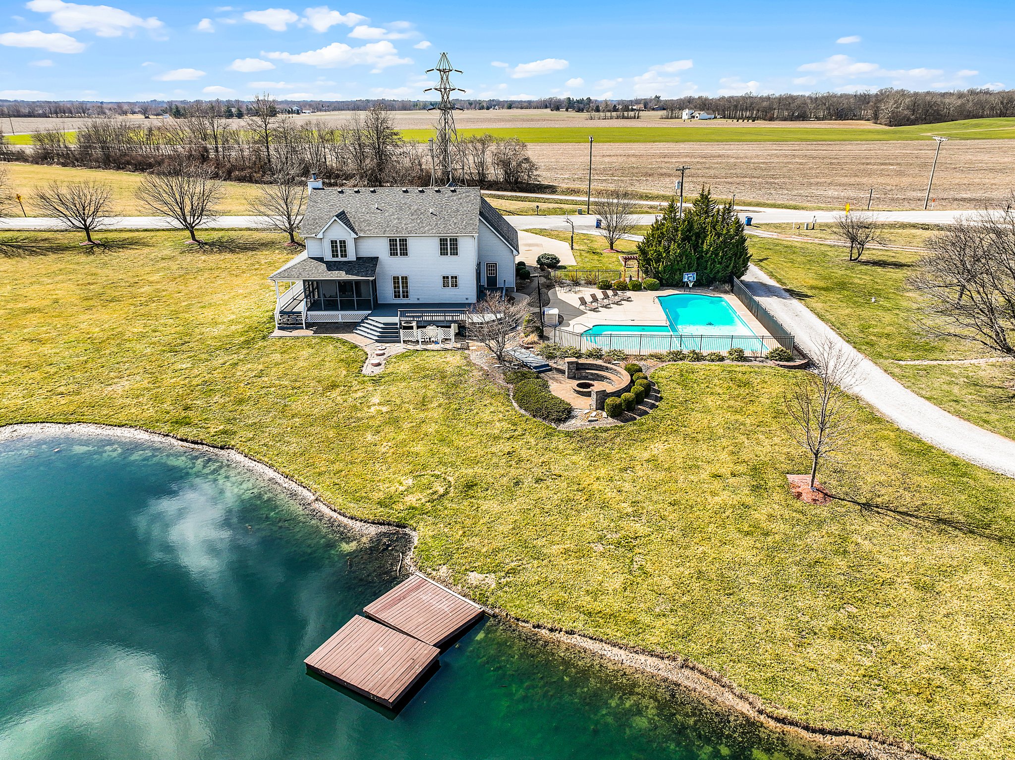 Aerial view of backside of property-acreage, home, inground pool, large pond and dock