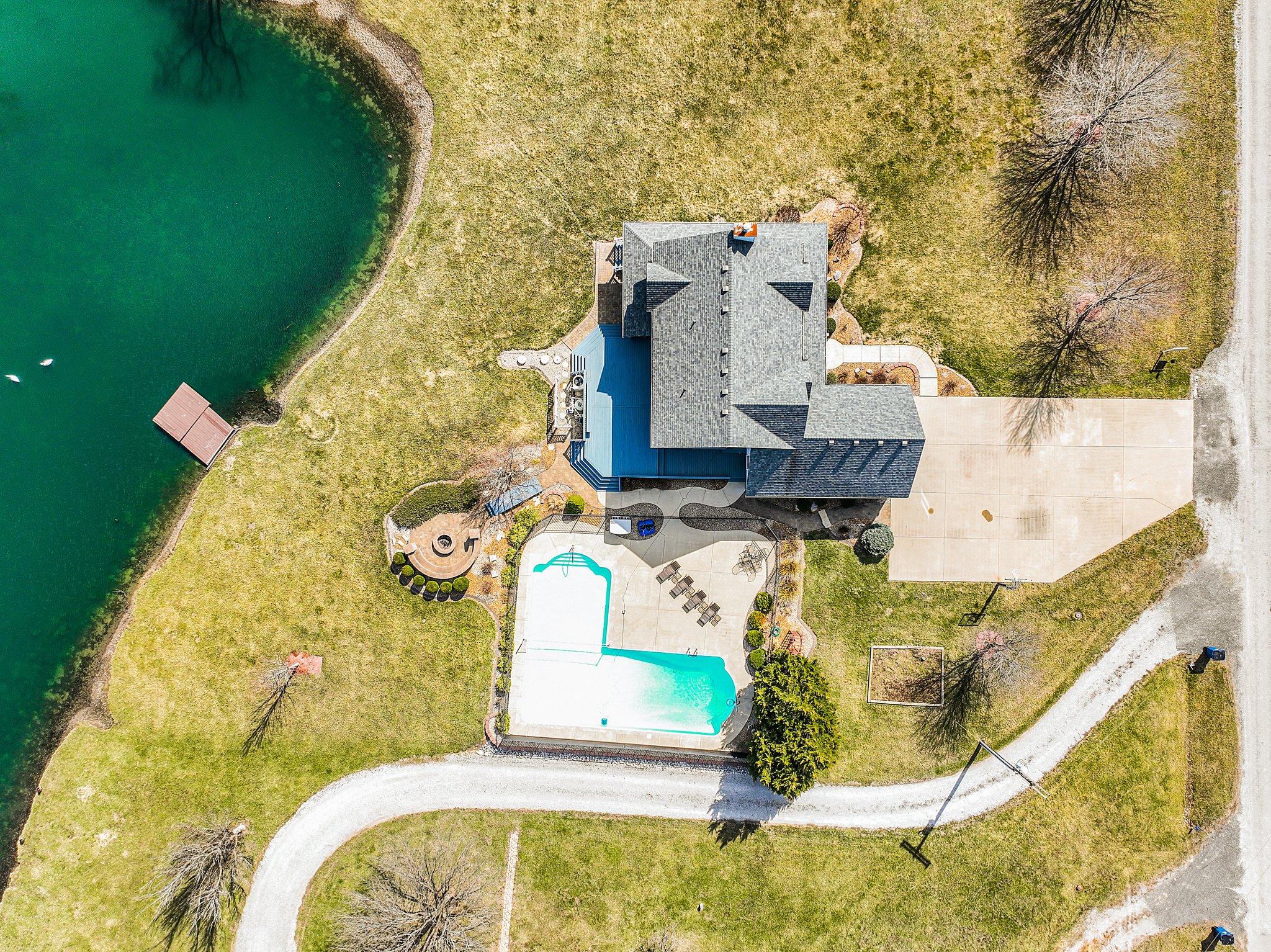 Aerial view of backside of property-acreage, home, inground pool, large pond and dock