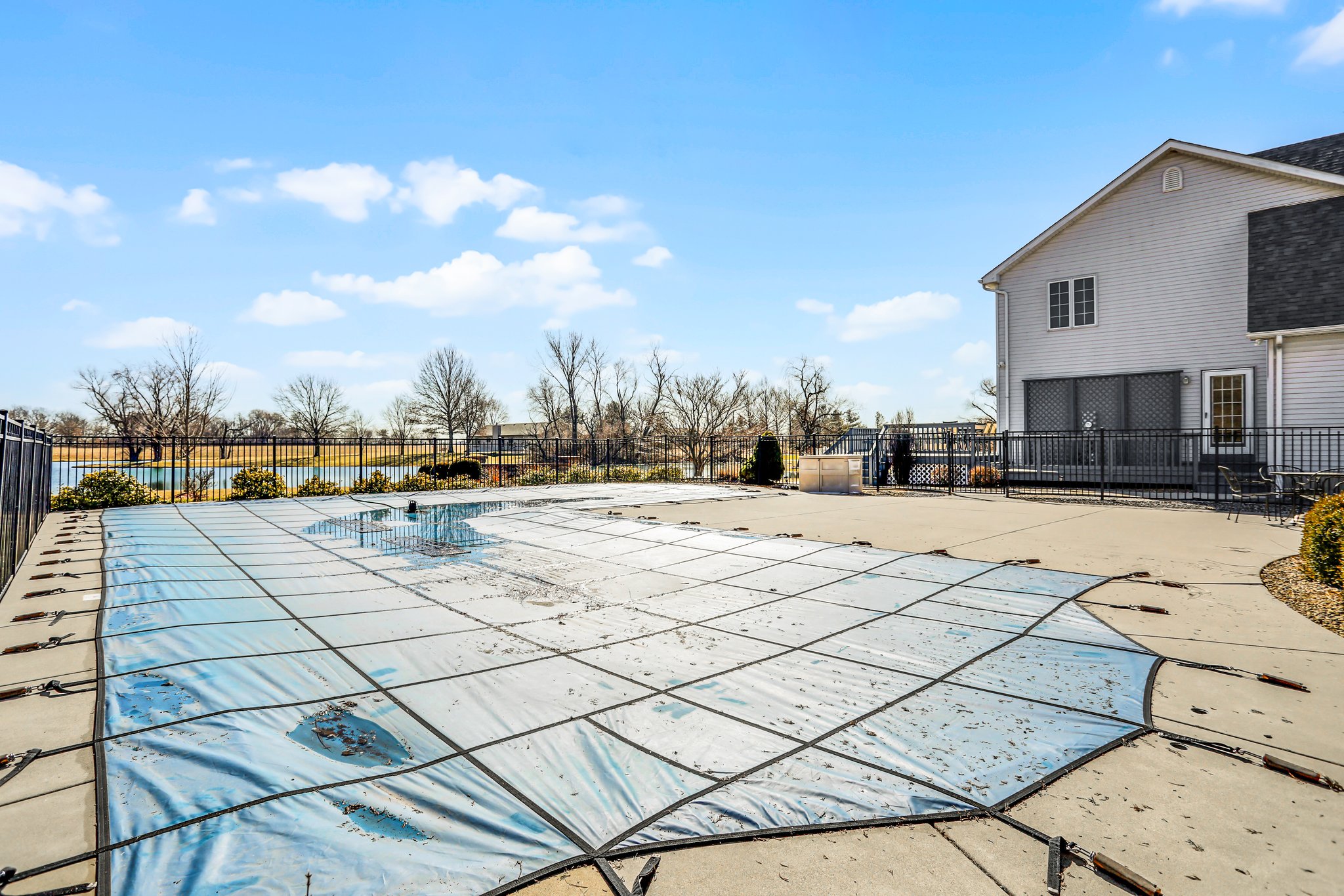Inground pool with cover, fencing and concrete patio