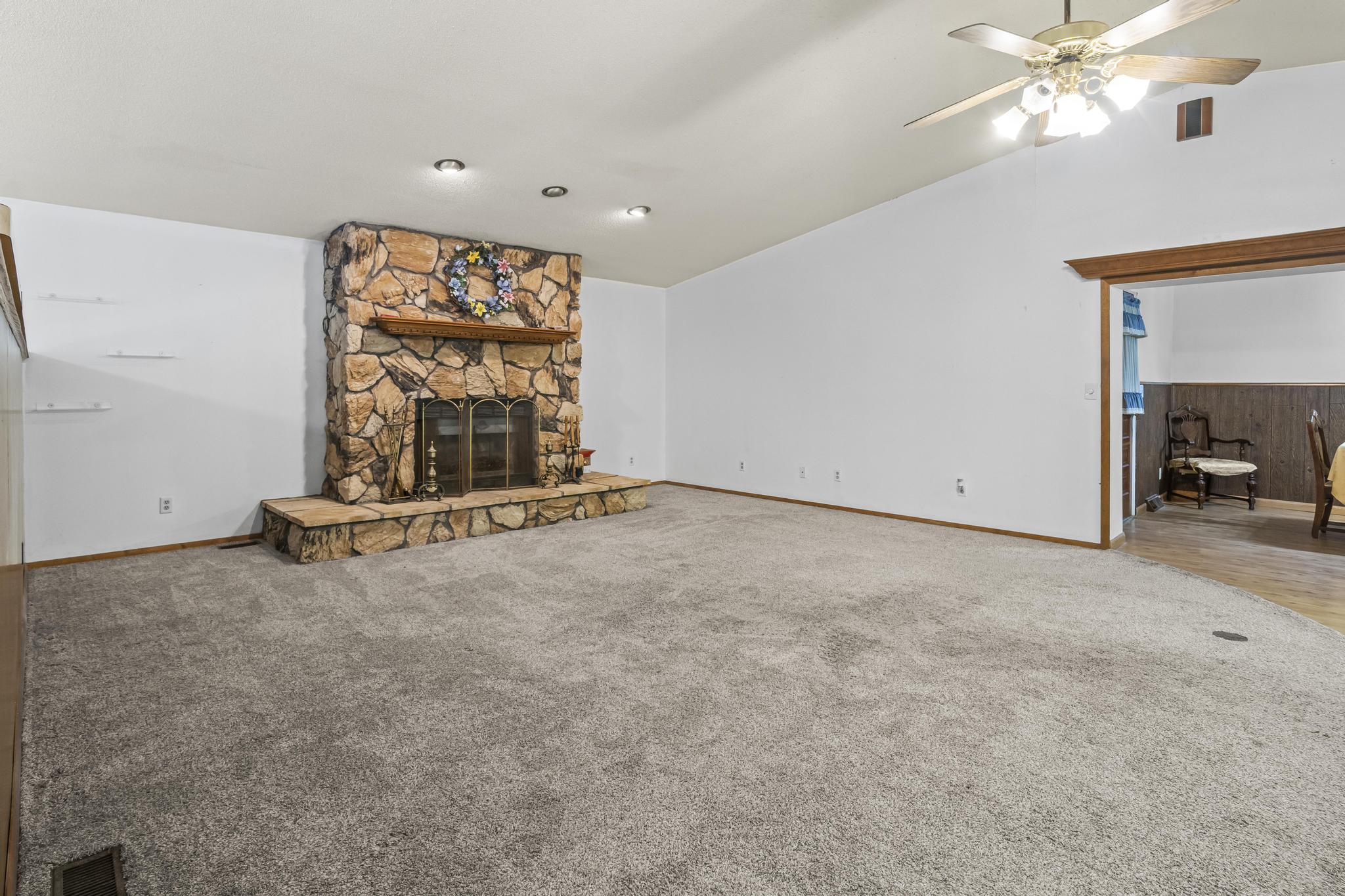 Great room, stone wood-burning fireplace and carpet