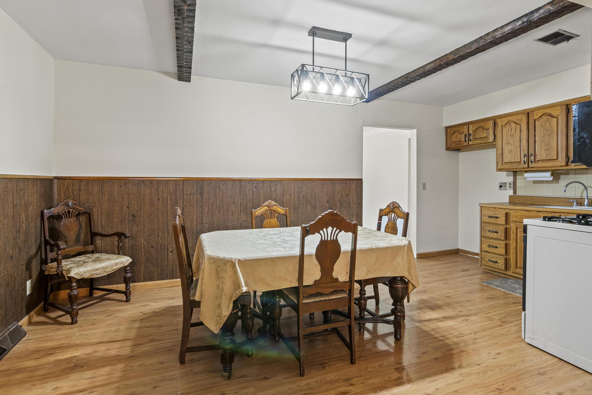 Eat-in Kitchen, ceiling beams, and laminate wood-style flooring