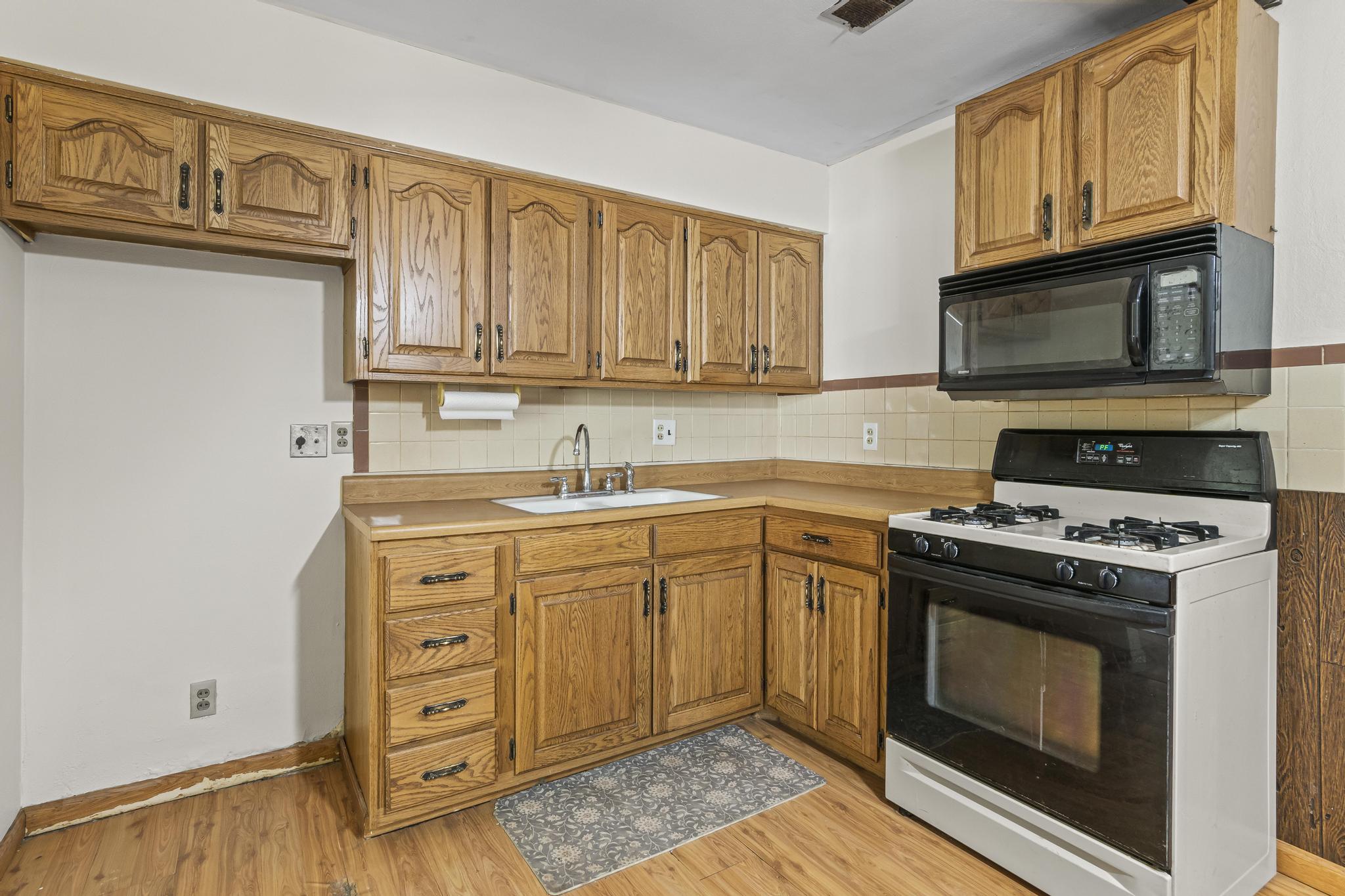Kitchen, range/oven gas, microwave, and laminate wood-style flooring
