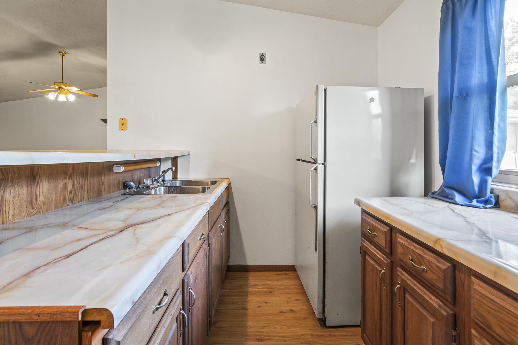 Wet bar, refrigerator, and laminate wood-style floor