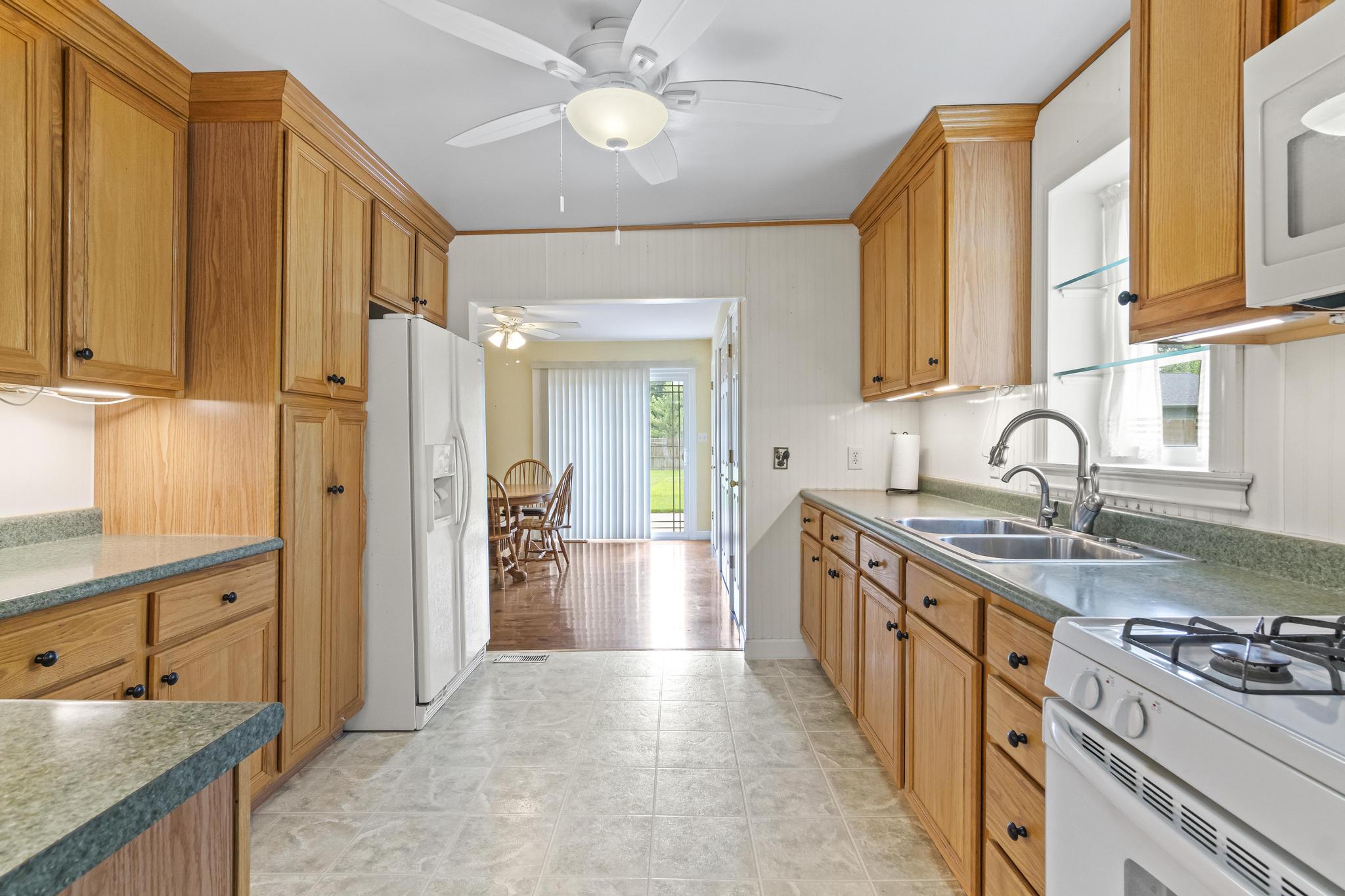 Kitchen with appliances, updated light cabinetry with under cabinet lighting and light colored flooring