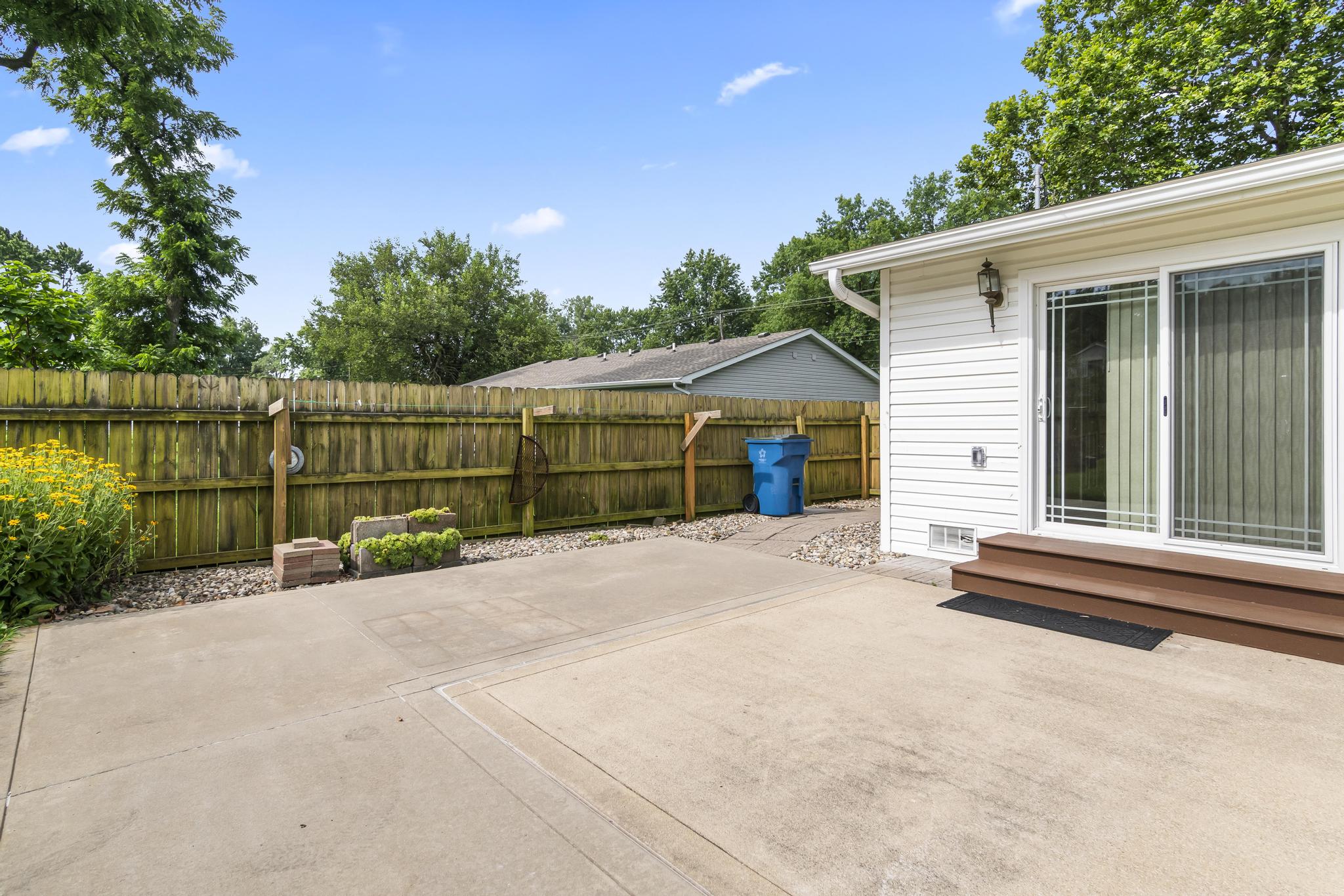 Back of structure featuring patio, and wood privacy fencing