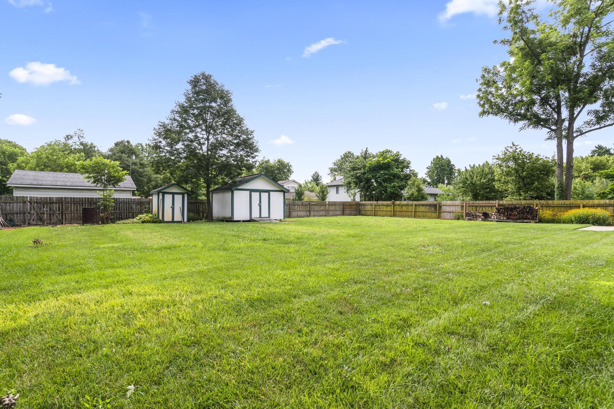 Backyard featuring wood privacy fencing and utility sheds