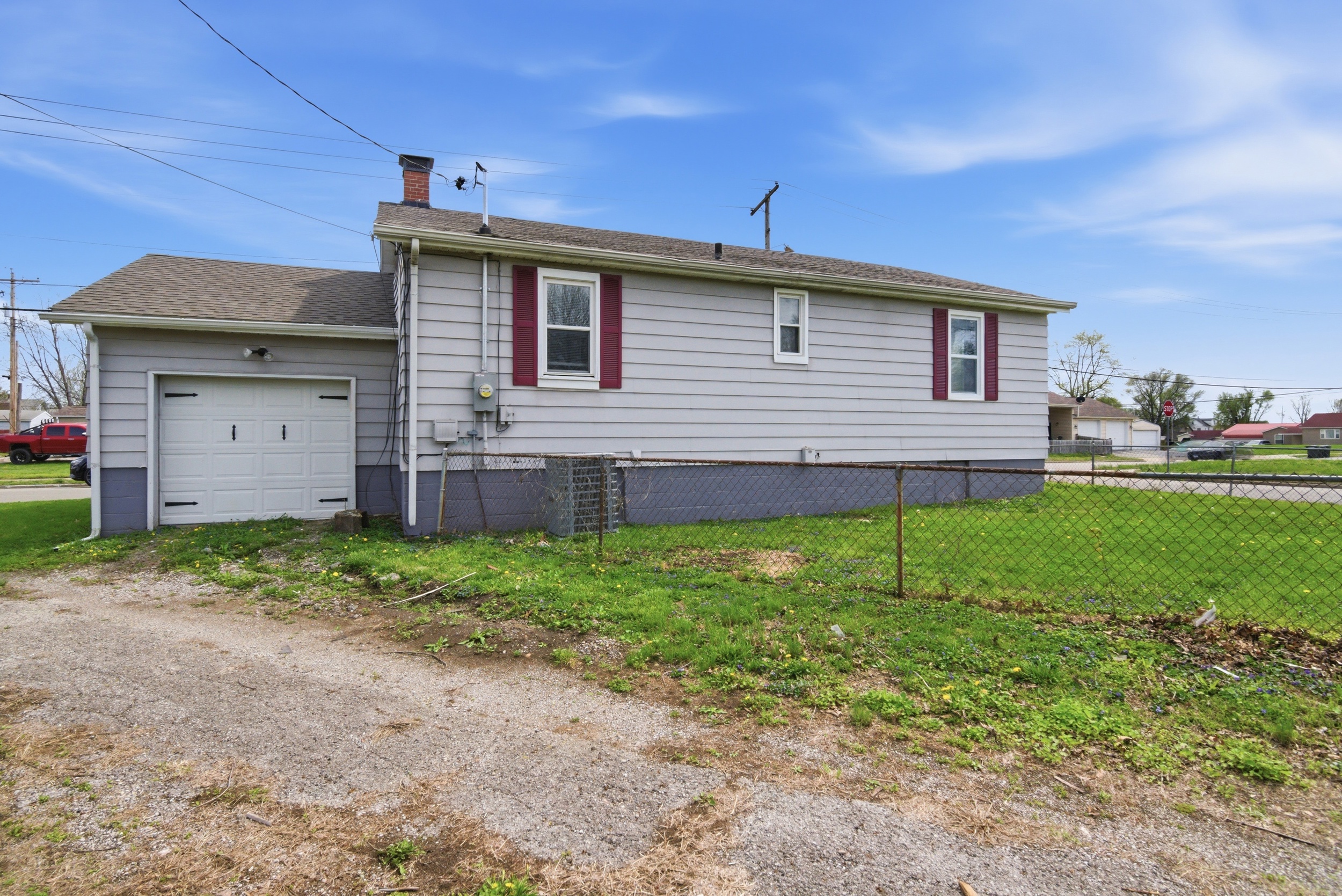 Exterior view of attached single car garage, grey siding and fenced yard at 1929 Beckwith St. Madison.